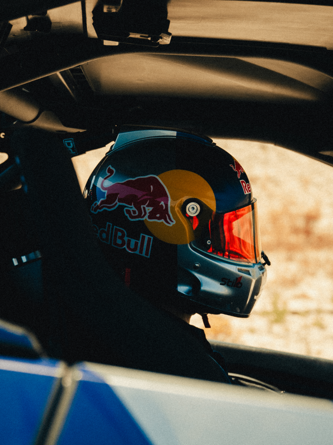 Close-up of a driver wearing a Red Bull racing helmet inside the Can-Am buggy