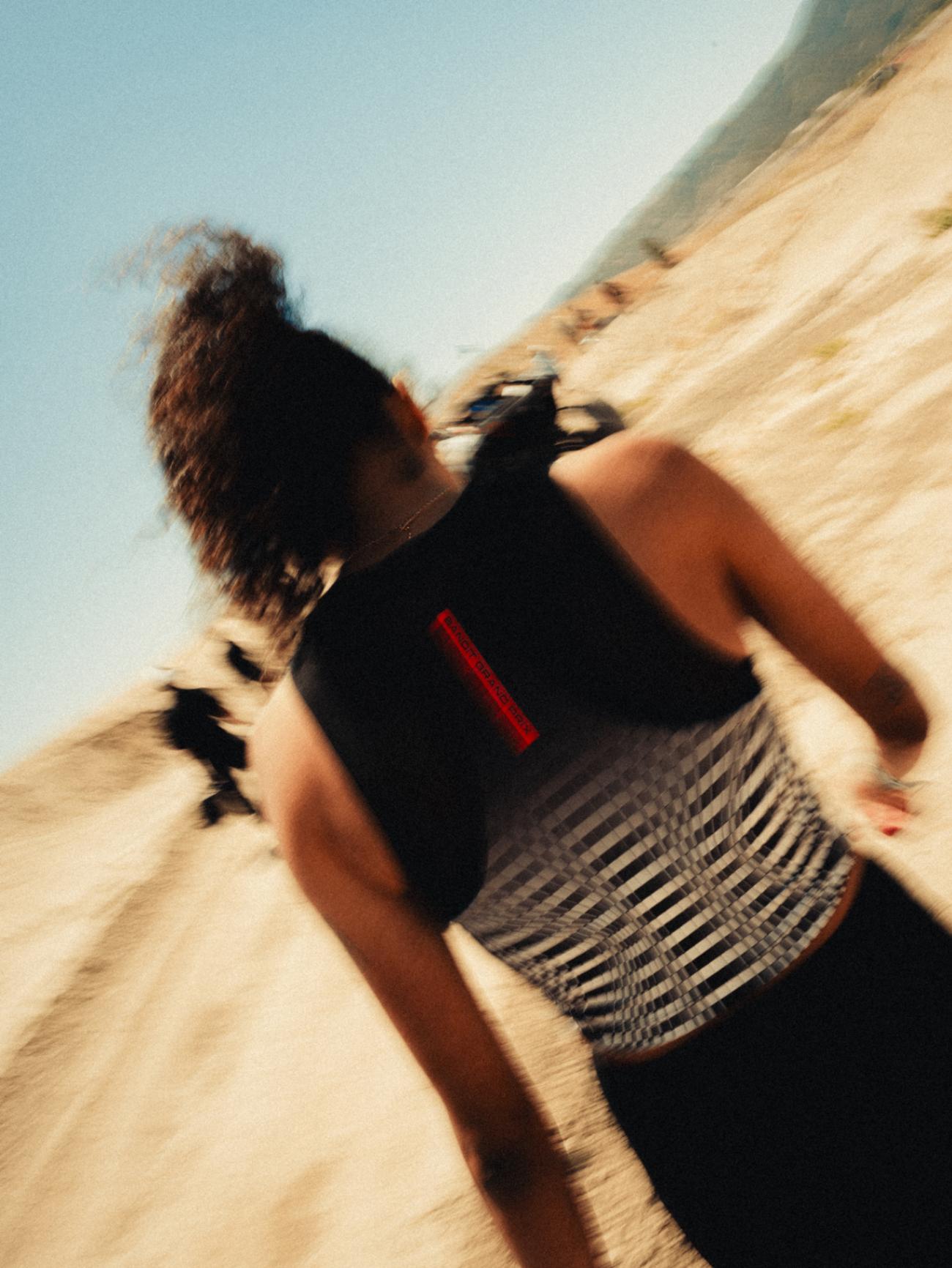 Runner in a Bandit Grand Prix jersey sprinting down a sandy slope