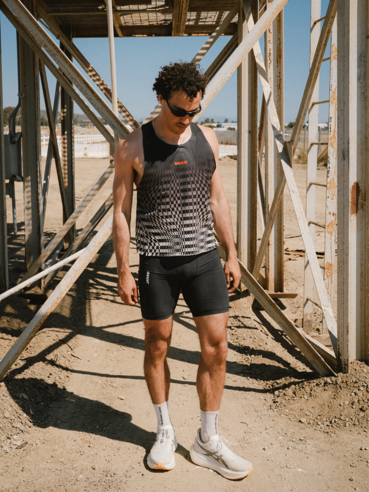 Runner in Bandit kit standing beneath a weathered steel structure